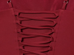 Detail of burgundy dress lace-up back design with adjustable straps and silver metal buckles