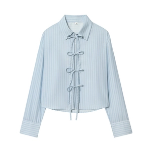 Close-up of white size S label on a light blue striped poplin shirt with bow ties
