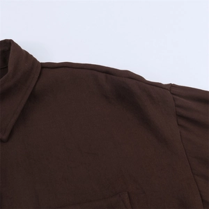 Detail of the classic lapel collar and seamless shoulder stitching on a brown shirt