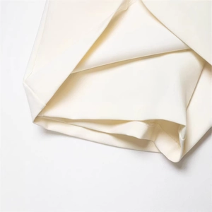 Close-up of elegant ivory wide-leg trousers with premium stitching and matching belt