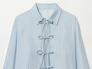 Detail of light blue striped poplin shirt with triple bow-tie closure and fine texture