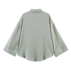 Back view of a loose-fit light sage green long-sleeve shirt with drop shoulders