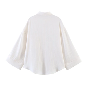 Detail view of the breathable cotton fabric texture on the back of a beige loose-fit shirt