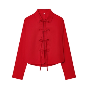 Detailed flat lay of red poplin shirt featuring four bow-tie ribbon closures and sharp collar