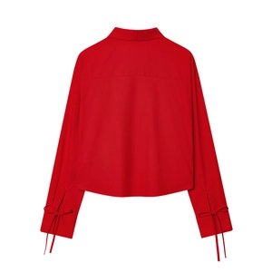 Detail of red poplin shirt featuring stylish bow tie-up cuffs and back yoke stitching