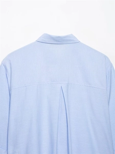 Detail of light blue striped shirt back featuring yoke and box pleat design
