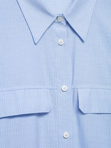 Close-up of light blue striped shirt featuring white buttons and flap chest pockets