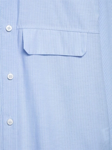 Detail of light blue striped shirt featuring white buttons and a front flap pocket