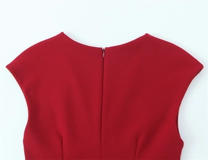 Détail d'une robe rouge montrant une fermeture éclair invisible et une texture de tissu lisse