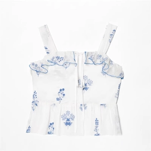 White off-shoulder summer dress with blue floral embroidery and ruffle details