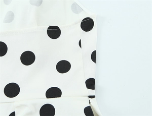 Gros plan détaillé du motif à pois noirs sur tissu blanc avec coutures précises