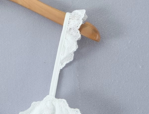 Detailed view of white lace trim shoulder straps with delicate floral embroidery