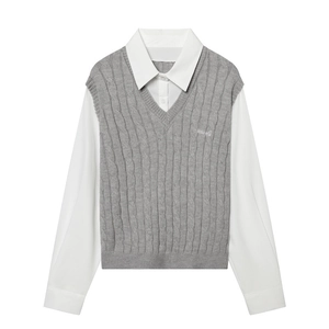 Détail du gilet en maille torsadée grise avec col chemise blanc et broderie sur la poitrine