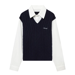 Détail du gilet en maille bleu marine à col en V et chemise blanche à broderie