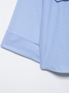 Close-up of light blue striped shirt showing fabric texture and cuff stitching detail