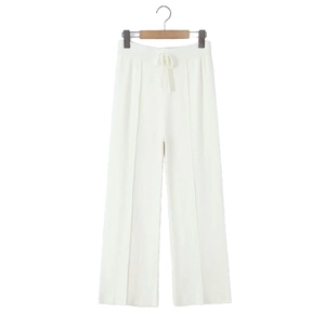 Détail d'un pantalon en maille crème à taille haute avec cordon et plis verticaux