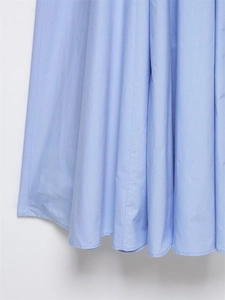 Dettaglio dell'orlo ondulato azzurro che mostra la trama liscia e l'elegante drappeggio