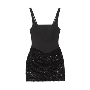 Détail d'une mini robe noire avec corsage mat et jupe à sequins froncée scintillante
