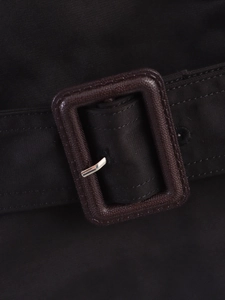 Close-up of trench coat belt detail featuring resin buckle and metallic pin buckle