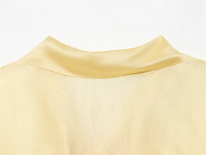 Detailed view of the smooth collar texture on light yellow silk satin blouse