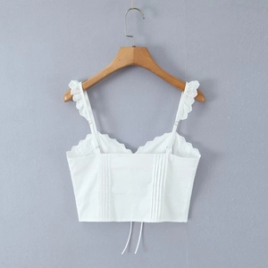 Detail showing white lace trim camisole with ruffle straps and back tie design