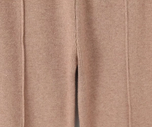 Détail rapproché du pantalon en maille camel montrant les coutures et la finition précise