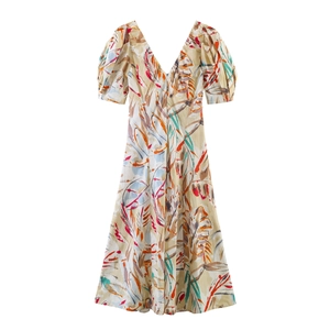 Detailed macro view of tropical leaf print and V-neck on beige short sleeve dress