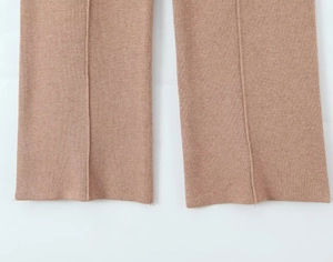Détail du pantalon en maille camel avec pli central marqué et finitions précises du bas