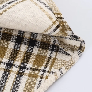 Detail shot of sturdy stitching and linen texture on yellow and black plaid skirt