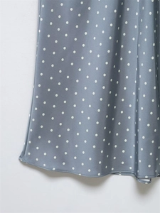 Detail of light blue polka dot skirt showing silky fabric texture and neat hemline