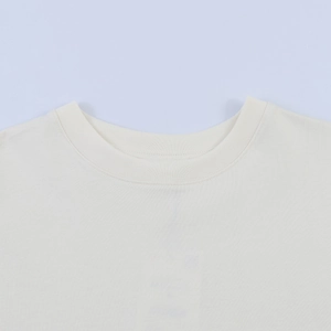 Detail of the crew neck collar and high-quality knit fabric on a minimalist beige T-shirt