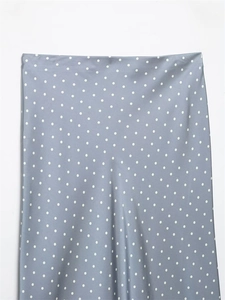 Close-up of elegant grey-blue satin skirt featuring a classic white polka dot pattern