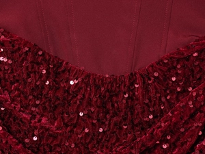 Détail de paillettes rouges sur velours plissé avec coutures précises sur robe élégante