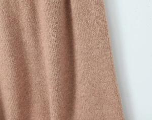 Vue macro détaillée montrant la texture du tricot camel avec un motif de côtes verticales