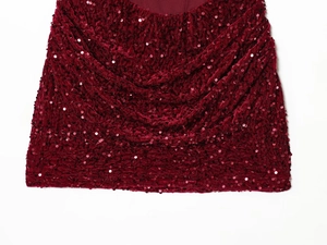 Détail macro du tissu à paillettes bordeaux avec plis élégants et texture velours