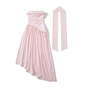 Détail d'une robe bustier rose clair avec des fronces et un ourlet asymétrique chic
