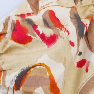Macro shot of vintage floral print fabric with abstract red and orange brushstroke patterns