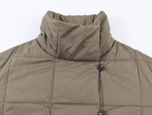 Gros plan du col montant d'un manteau d'hiver matelassé avec boutons noirs