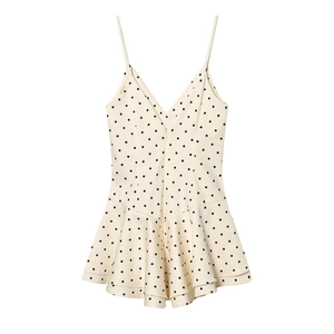 Detail of cream polka dot romper dress featuring spaghetti straps and ruffled hem design