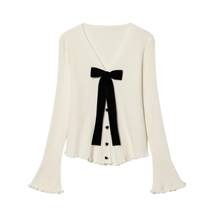 Dettaglio cardigan in maglia con fiocco di velluto e bottoni a cuore neri