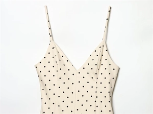 Detail of V-neck off-white bodysuit dress with black polka dots and thin straps