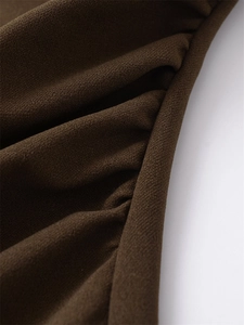 Macro shot of dark brown crinkled fabric texture showing detailed draped stitching details