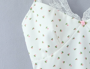 Détail d'un top caraco floral avec dentelle blanche et rose en ruban 3D sur le décolleté