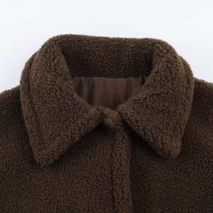 Detail shot of a brown sherpa coat collar and soft fleece lining for autumn winter