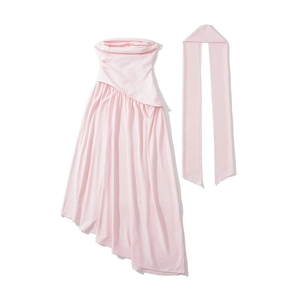 Détail de la robe moulante rose clair avec taille croisée et ourlet asymétrique