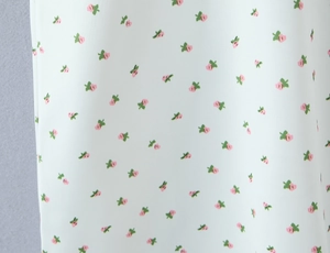 Détail macro du tissu de robe d'été avec petites fleurs roses et motifs de feuilles vertes