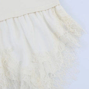 Detail of cream rib-knit fabric with asymmetric satin hem and delicate eyelash lace trim