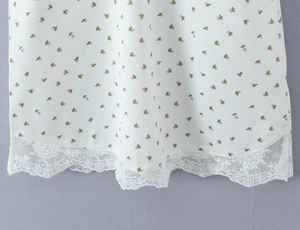 Détail de tissu blanc fleuri avec fleurs roses et bordure en dentelle blanche brodée