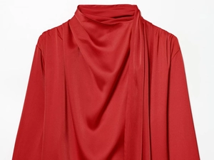 Macro shot of dark red satin blouse showing the elegant cowl neck and fabric luster
