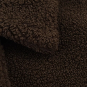 Macro detail of dark brown fleece texture showing thick curly wool grain on the coat
